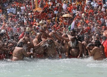 Sadhus, or Hindu holy men, take a dip in the Ganges river during